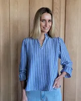 Blusa de algodón con cuello mao y volados, mangas largas con puños elásticos y corte holgado.