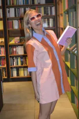 Camisola corta con cuello camisero y mangas cortas, con diseño a rayas verticales en tonos naranja, rosa y celeste.