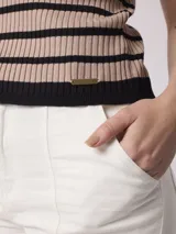 Remera tejida a rayas horizontales color beige y negro, con cuello tipo polo y mangas cortas.