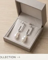 Caravanas colgantes de acero con diseño de aro alargado y perla barroca natural.