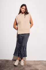 Falda midi de poliéster color negro con estampado de lunares blancos.