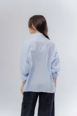 Camisa oversize celeste de algodón, con cuello camisero clásico y cierre frontal de botones.