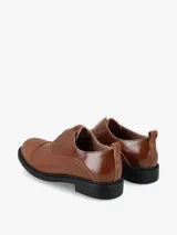 Mocasín tipo slip-on de cuero color marrón, con diseño minimalista, puntera reforzada y suela plana de goma negra.
