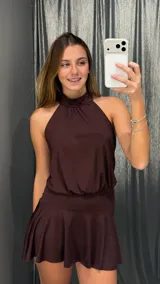Vestido corto color chocolate, con escote halter y diseño de falda con vuelo. Confeccionado en tejido con acabado brillante.