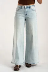 Jean de corte wide leg con tiro medio, confeccionado en denim de algodón con un lavado claro desgastado. Presenta diseño de cinco bolsillos y cierre frontal con botón y cremallera.