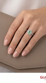 Anillo de plata 925 con piedra central ovalada de color verde claro, rodeada por un halo de pequeñas piedras brillantes y banda decorada con cristales.