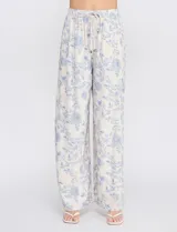 Pantalón palazzo de tiro alto con estampa floral azul sobre base beige, corte de pierna ancha, cintura elastizada con cordón de ajuste y bolsillos laterales.