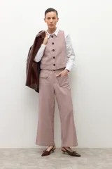 Pantalón tipo culotte de tiro alto con estampado de cuadros pequeños en tonos beige y marrón. Presenta bolsillos frontales tipo parche y corte recto de pierna ancha.