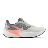 Championes de running New Balance FuelCell Rebel v5, color gris con detalles en naranja y suela blanca.
