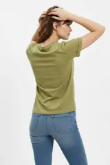 Remera blanca de manga corta y corte holgado, confeccionada en algodón. Presenta un estampado frontal de estilo vintage con una mariposa azul, flores y la inscripción "Find your peace of mind, free your spirit".