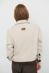 Chaqueta de pana color azul oscuro, con cuello camisero, cierre frontal con botones y bolsillos laterales. Diseño de corte recto y manga larga.