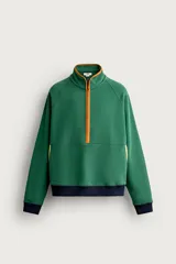 Sudadera regular fit color verde con cuello subido y cierre frontal de cremallera corta en tono naranja a contraste. Cuenta con mangas largas raglán, bolsillos frontales tipo canguro y puños y cintura en canalé de color azul marino.