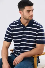 Remera polo de manga corta con diseño de rayas horizontales en color azul marino y rosado. Cuenta con cuello camisero, cierre frontal con botones y calce clásico.