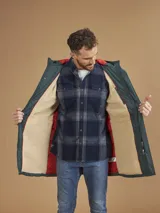 Campera de abrigo azul marino con capucha, cierre frontal con botones y cremallera, múltiples bolsillos y forro interior naranja.