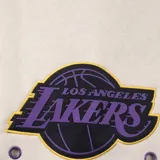 Pantalón de jogging color crema con puños ajustados, cintura elástica con cordón y logo de Los Angeles Lakers en el bolsillo lateral.