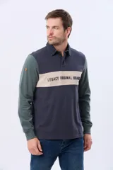 Remera tipo polo de manga larga con diseño color block en azul marino, verde y una franja central en beige con el texto Legacy Original Brand estampado. Presenta cuello camisero con cierre de botones y puños acanalados.