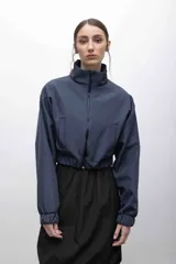 Campera cropped azul con cuello alto y cierre frontal. Cuenta con bolsillos funcionales, puños elastizados e interior de micropolar.