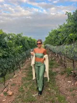 Pantalón de cuero sintético color verde safari, corte recto, con flecos largos en los laterales.