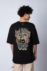 Remera de corte oversize color blanco, con cuello redondo y mangas cortas. Presenta un pequeño logo estampado en el pecho y un diseño gráfico grande en la espalda que incluye la frase 'Good Children' e ilustraciones de un ángel y llamas.