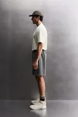 Short tipo jogger de algodón con interior afelpado, cintura elástica ajustable con cordón, bolsillos frontales y bolsillo trasero. Presenta un efecto lavado y estampado gráfico a contraste en el frente.
