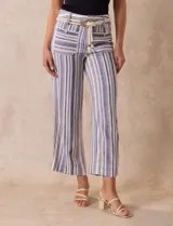 Pantalón de lino a rayas verticales en tonos azul, beige y blanco, con corte wide leg, pretina con pasadores, cierre y botón. Incluye cinturón de soga con hebilla redonda.