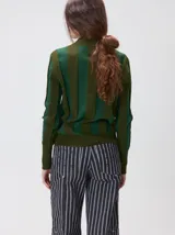 Sweater de punto con diseño de rayas verticales en tonos negro y gris oscuro. Presenta cuello alto tipo polera, mangas largas con puños ajustados y ruedo elástico. Incluye un pequeño bordado en color rojo en el pecho.