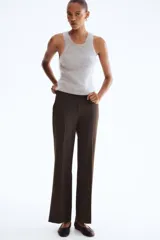 Pantalón de vestir color marrón oscuro, corte bootcut, con raya marcada en el frente y el reverso. Presenta pretina prolongada con cierre oculto y bolsillos al bies y ribeteados en la parte trasera.