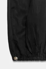 Pantalón bombacho de tiro medio color vino, con cintura ajustable mediante cordón y puños elásticos ajustables con botón en los tobillos.