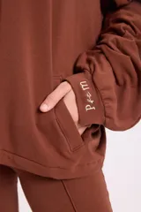 Campera holgada de felpa color gris, con cuello alto, cierre frontal completo, mangas tipo murciélago y bolsillos laterales.