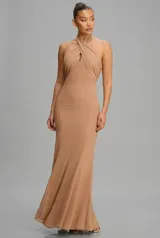 Vestido largo de corte sirena color tostado, con cuello halter cruzado y espalda semi descubierta.