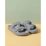 Sandalias chancletas de goma color beige con diseño texturizado en la suela, doble tira ajustable con hebillas y estilo slip-on.