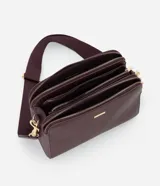 Cartera bandolera de tamaño mediano en cuero sintético color bordó, con formato rectangular y múltiples compartimentos con cierre de cremallera. Incluye correa de hombro ajustable en grosgrain y herrajes metálicos dorados.