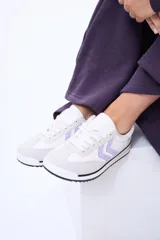 Championes urbanos de diseño moderno, combinan paneles en color blanco y gris claro con detalles en lila en los laterales. Presentan suela plana con una fina línea negra y cordones al tono.