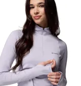 Remera deportiva de manga larga con cierre frontal parcial, cuello alto y orificios para los pulgares en los puños. Presenta un diseño técnico en color lila con el logo de la marca estampado en el pecho.