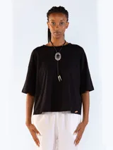Remera negra de manga corta, con diseño clásico de cuello redondo y corte holgado.