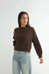 Cardigan de punto color marrón chocolate, con cuello redondo, cierre frontal de botones y diseño de costuras verticales visibles. Presenta puños y ruedo acanalados.