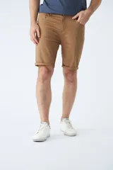 Bermuda clásica de jean color beige, con cinco bolsillos, cierre con cremallera y botón.