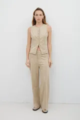 Chaleco de gamuza color caramelo, con cierre frontal de botones y bolsillos laterales simulados.