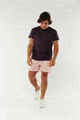 Short de baño color rosa claro, con cintura elástica y cordón ajustable. Cuenta con bolsillos laterales y un bolsillo trasero, confeccionado en tela ligera de secado rápido.