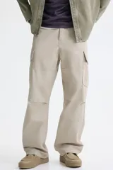 Pantalón cargo de lona de algodón con corte relajado, bolsillos laterales con solapa, bolsillos al bies y pliegues reforzados en las rodillas.