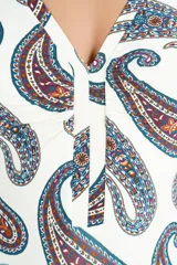Malla enteriza de color blanco con estampado paisley en tonos azul, rojo y tostado, escote en V y detalles fruncidos en el centro.