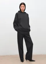 Pantalón de vestir gris oscuro, de corte recto y holgado, con tiro medio y costuras frontales marcadas en las piernas.