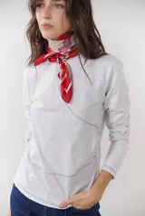 Remera blanca de manga larga con cuello redondo y costuras decorativas en contraste de color negro.