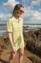 Camisa de manga corta oversize en lino rayado, con cuello camisero, cierre frontal con botones y bordado playero en el frente.