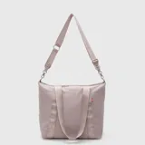 Bolso tipo tote de diseño acolchado con costuras horizontales, marca Bubba. Cuenta con doble asa de mano y una correa larga ajustable y extraíble, ambas con el logo de la marca estampado. Presenta un cierre superior y una pequeña etiqueta decorativa en el lateral.