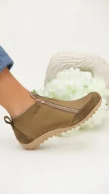 Zapato bajo de cuero color beige con refuerzos en gamuza en la puntera y el talón. Cuenta con doble cierre lateral diagonal, presilla trasera y suela de goma con relieve.