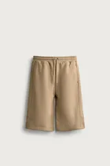 Bermuda estilo jogger de ajuste relajado, color beige, con cintura elástica ajustable mediante cordón y bolsillos delanteros.