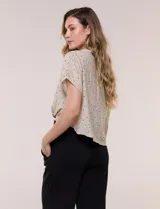 Blusa crop cruzada Allie Rose de tela liviana negra con estampado de lunares blancos, escote en V y cuello camisero.