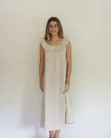 Vestido midi de lino color beige, de corte suelto, sin mangas y con escote redondo decorado con un volado amplio.