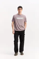Remera de manga corta color gris topo, con cuello redondo y estampa frontal de estilo urbano con texto en tono claro.